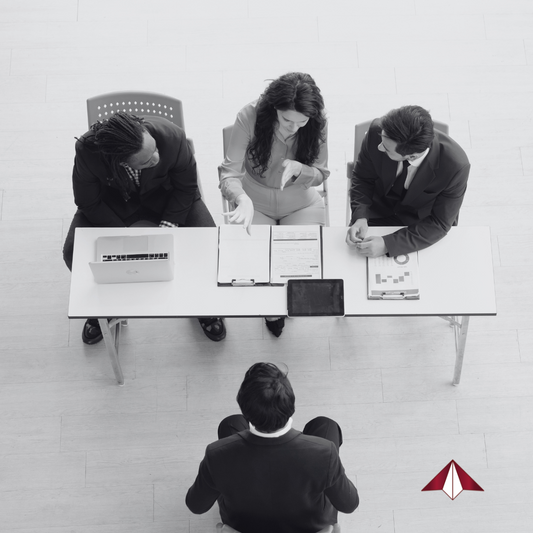 Senior executive in interview preparation session with a coach, reviewing leadership talking points and practicing mock interview questions.